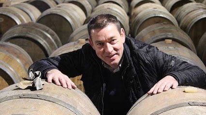 Stéphane Mordeles au cœur de la cave du Dragon Rouge à Dinard, entre les fûts de chêne